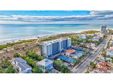 Stunning aerial view of a beachfront condo complex with tennis courts and a pool, near the ocean at 420 Beach Rd # 203, Sarasota, FL 34242