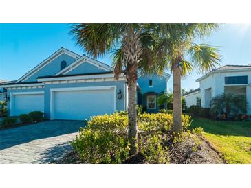 Two-car garage, light blue exterior, landscaping, and a paved driveway at 4326 Tamarind Pl, Bradenton, FL 34203