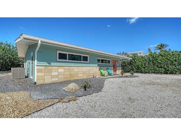 Side view of a cute beach house with clean lines and stone accents surrounded by fresh landscaping at 4626 Gleason Ave, Sarasota, FL 34242