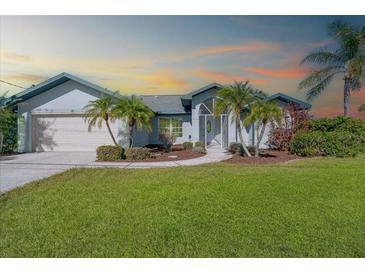 One-story home with landscaped lawn and palm trees at 527 Rotonda Cir, Rotonda West, FL 33947