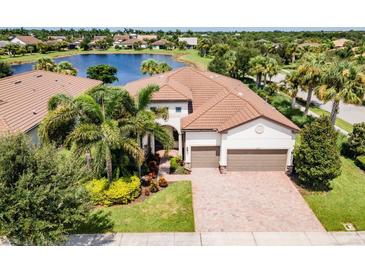 Luxury home with lake view, brick driveway and lush landscaping at 5610 Rain Lily Ct, Sarasota, FL 34238