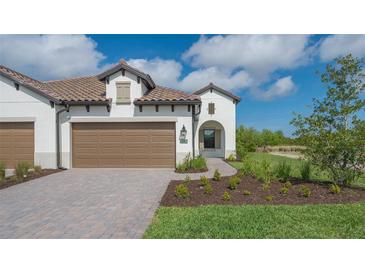 Two-car garage with paver driveway and nicely landscaped front yard at 26903 Pavin Dr, Englewood, FL 34223