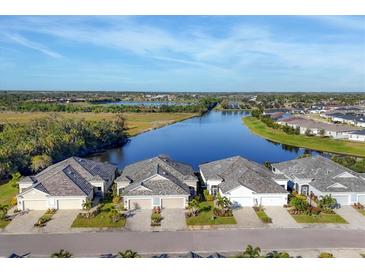 Stunning aerial view of homes nestled along a tranquil waterfront, showcasing the community's serene setting and beautiful landscaping at 3115 Trustee Ave, Sarasota, FL 34243