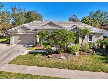 Single-story home with tile roof, landscaping, and attached garage at 396 Lansbrook Dr, Venice, FL 34292