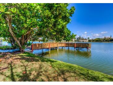 Private wooden dock extending over calm lake water at 4067 Lake Bayshore Dr # 302, Bradenton, FL 34205