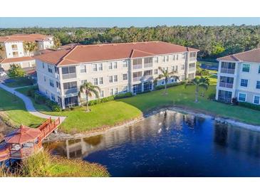 Beautiful condominium complex featuring a lake with a gazebo, lush landscaping and well-maintained exterior at 500 San Lino Cir # 511, Venice, FL 34292