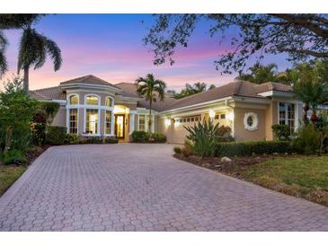 Elegant two-story home with a paver driveway and landscaped yard at 7041 Beechmont Ter, Lakewood Ranch, FL 34202