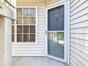 Condo building entrance with gray door and storm door, showing address number 402 at 850 S Tamiami Trl # 402, Sarasota, FL 34236