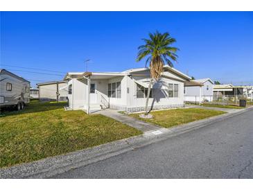 Single-wide manufactured home with carport and palm tree at 1111 49Th Avenue W Dr, Bradenton, FL 34207