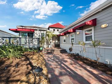 Inviting home exterior with landscaped walkway and red awnings at 3455 Winding Oaks Dr # 28, Longboat Key, FL 34228