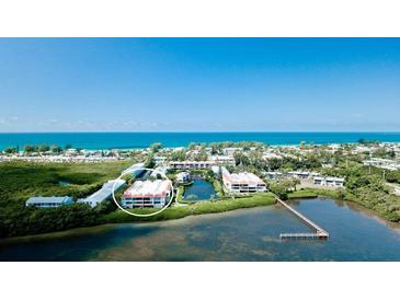 Aerial view of condo community near the ocean, showing buildings and landscaping at 3705 E Bay Dr # 212, Holmes Beach, FL 34217