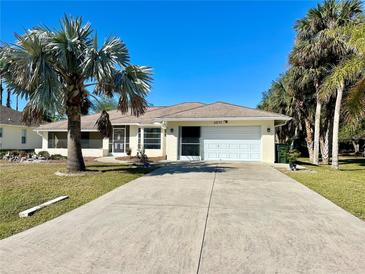 Single-story home with a driveway, garage, and mature landscaping at 5277 San Luis Ter, North Port, FL 34286