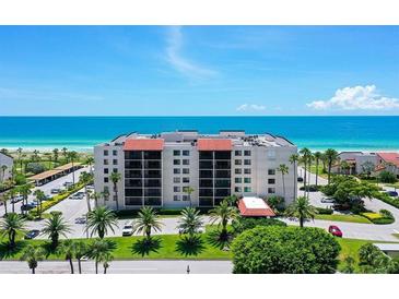 Coastal condo building with ocean views, lush landscaping, and ample parking at 2045 Gulf Of Mexico Dr # M1-502, Longboat Key, FL 34228