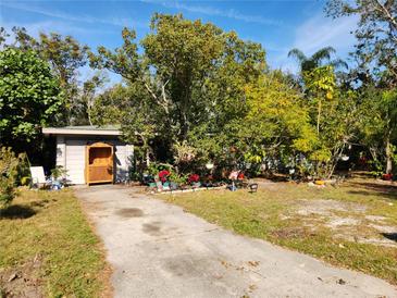 Ranch home with a spacious front yard, mature trees, and colorful landscaping at 3181 Irving St, Sarasota, FL 34237