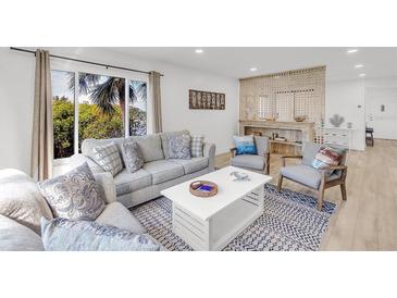 Bright living room with comfy seating, large windows, and coastal decor at 3320 Gulf Of Mexico Drive # 208C, Longboat Key, FL 34228