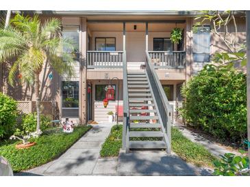 Two-story condo building with stairs leading to individual units and landscaping at 1708 Glenhouse Dr # 413, Sarasota, FL 34231