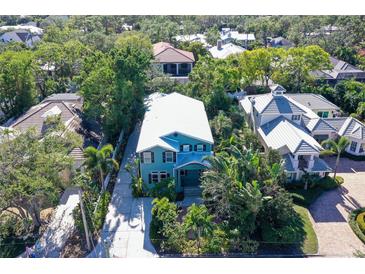 Aerial view of a teal house with a white roof, surrounded by lush tropical landscaping at 1732 Hillview St, Sarasota, FL 34239