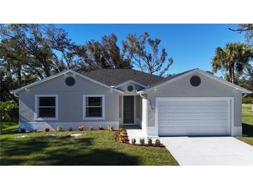 Charming single-story home with a well-manicured lawn, attached two-car garage, and a freshly painted exterior at 1859 Lamont St, North Port, FL 34288