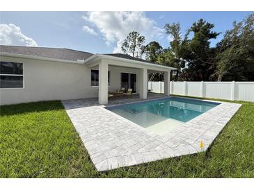 Beautiful backyard pool with patio and a well-maintained lawn, perfect for outdoor entertaining and relaxation at 1859 Lamont St, North Port, FL 34288