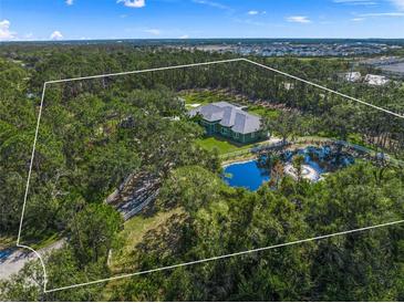 Aerial view of a single-Gathering home with a pond and lush landscape at 7051 Turtle Ln, Sarasota, FL 34241