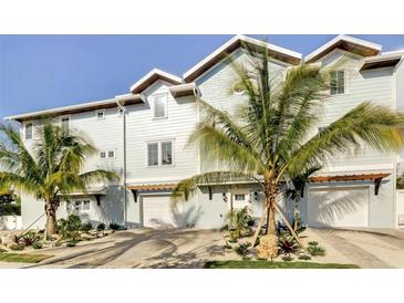 Stunning waterfront home with palm trees and attached garage at 2516 Avenue A, Bradenton Beach, FL 34217
