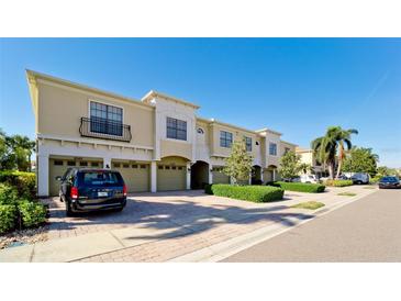 Tan three-story townhouses with attached garages, and lush landscaping at 4046 Overture Cir # 4046, Bradenton, FL 34209