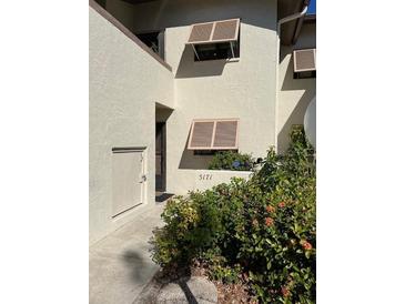 Condo building exterior featuring landscaped grounds and individual unit entrance at 5171 Willow Links # 23, Sarasota, FL 34235
