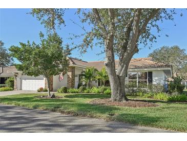 Single story home with landscaped yard and large trees at 5808 Garden Lakes Majestic, Bradenton, FL 34203