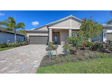 Charming single-story home with a well-manicured lawn, paver driveway, and attached two-car garage at 17744 Savory Mist Cir, Bradenton, FL 34211