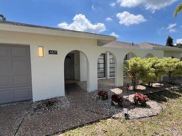 Charming single-story home with white exterior, arched entryway, and well-maintained landscaping at 4409 Eleuthera Ct, Sarasota, FL 34233
