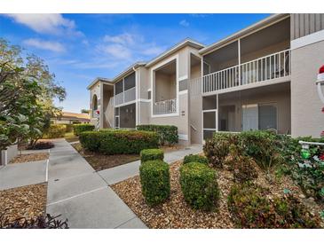 Exterior view of condo building with landscaped grounds and walkway at 9611 Castle Point Dr # 912, Sarasota, FL 34238