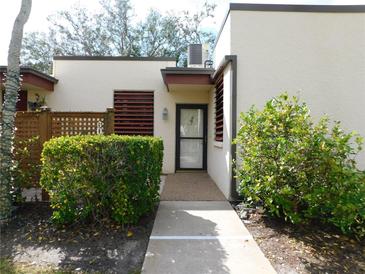 Inviting front entry with a walkway, lush landscaping, and a storm door at 302 Spring Lakes Blvd # 302, Bradenton, FL 34210