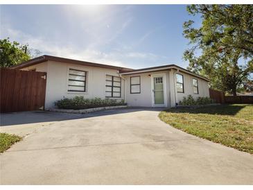 Updated home exterior with a landscaped yard and a long driveway at 3629 Taro Pl, Sarasota, FL 34232