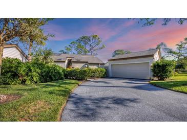 Attractive exterior featuring a two-car garage and lush landscaping at 4419 Glebe Farm Rd # 149, Sarasota, FL 34235