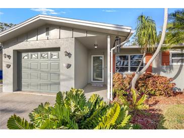 House exterior featuring a gray facade, attached garage, and landscaping at 2115 Cambridge Dr, Sarasota, FL 34232