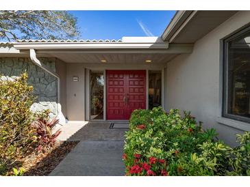 Inviting front entrance with red double doors and landscaping at 6143 Wilshire Cir # 19, Sarasota, FL 34238