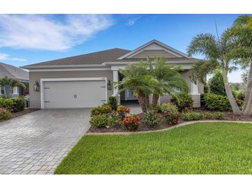 Charming single-story home featuring a two-car garage, landscaped yard, and a paver driveway at 13789 Old Creek Ct, Parrish, FL 34219