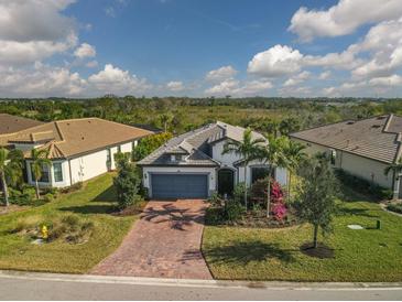 Single-Gathering home with brick driveway, landscaping, and a two-car garage at 17531 Colebrook Cir, Lakewood Ranch, FL 34202