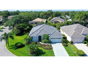 Single-story home with gray tile roof and lush landscaping at 8334 Sailing Loop, Lakewood Ranch, FL 34202