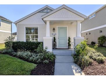 Charming home exterior with a light blue door, inviting porch, and landscaped yard at 12583 Sagewood Dr, Venice, FL 34293