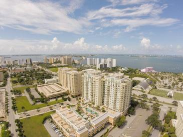 Stunning aerial view of the condominium complex with lush landscaping and bay views at 800 N Tamiami Trl # 403, Sarasota, FL 34236