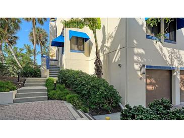 Unit exterior showcasing stairs, landscaping, and garage access at 1904 Harbourside Dr # 204, Longboat Key, FL 34228