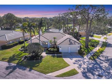 Beautiful single-story home with a tile roof, two-car garage, and lush landscaping at 2960 Sandringham Pl, Sarasota, FL 34235
