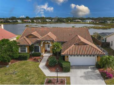 Attractive single-story home with tile roof, landscaped yard, and waterfront view at 4875 Wood Pointe Way, Sarasota, FL 34233