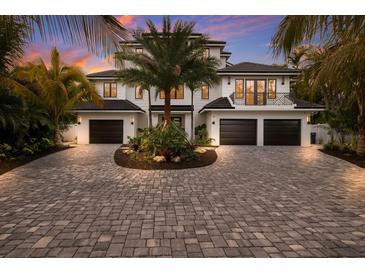 Two-story home with a three-car garage and a landscaped driveway at 518 Blue Heron Dr, Anna Maria, FL 34216