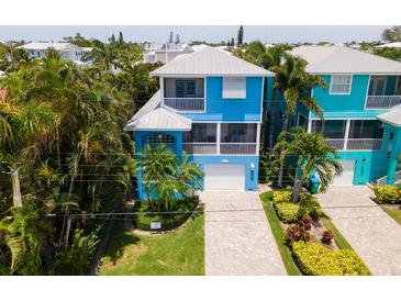 Aerial view of a charming blue house and neighborhood, near the beach at 7007 Holmes Blvd, Holmes Beach, FL 34217