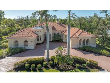 Aerial view of a luxurious home with a tile roof and lush landscaping at 855 Macewen Dr, Osprey, FL 34229