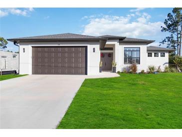 Charming single-story home with a two-car garage and landscaped front yard at 1256 Napoleon Rd, North Port, FL 34288