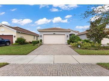 Single-story home with a two-car garage and landscaped front yard at 4905 Avila Lakes Dr, Wimauma, FL 33598