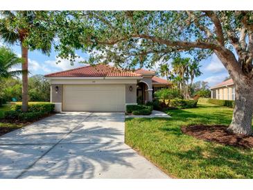 Single-story home with tile roof, attached garage, and lush landscaping at 608 Misty Pond Ct, Bradenton, FL 34212